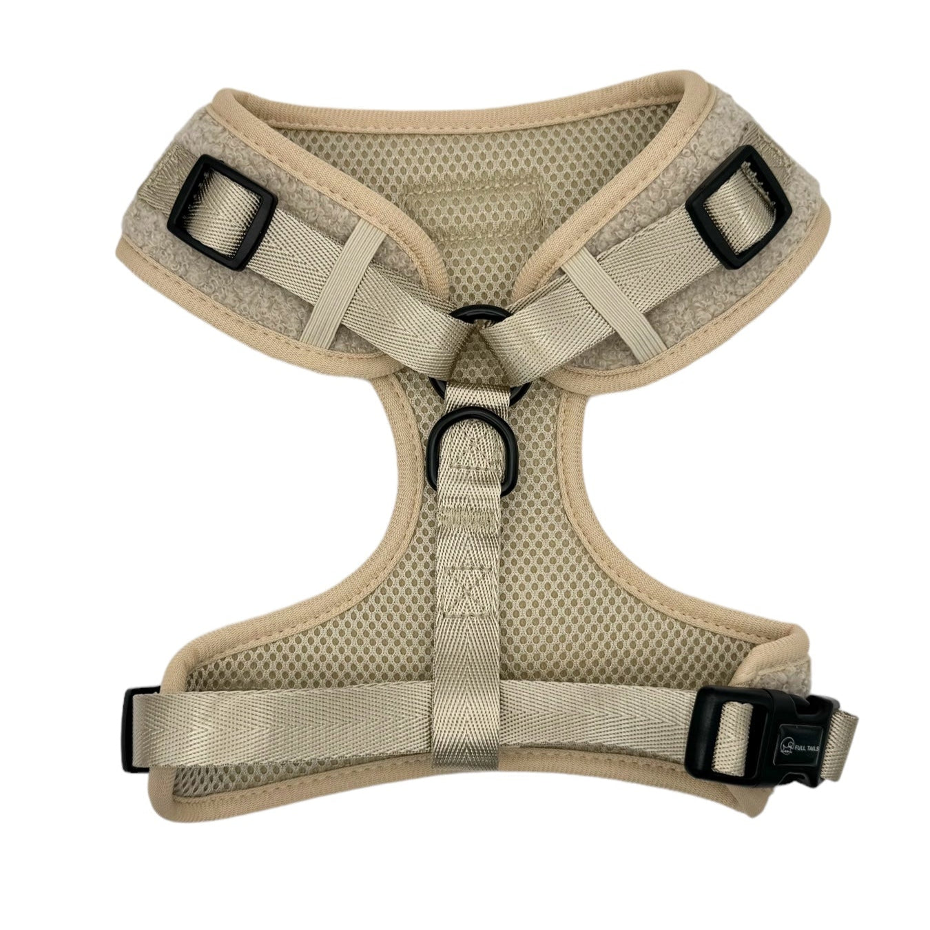 Beige dog harness with black buckles on a white background