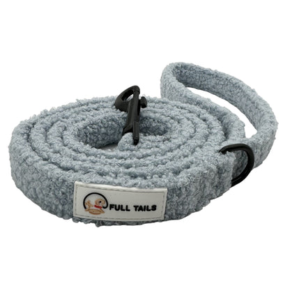 A gray teddy-textured dog leash with a padded handle and a metal clasp, featuring reflective stitching for safety.