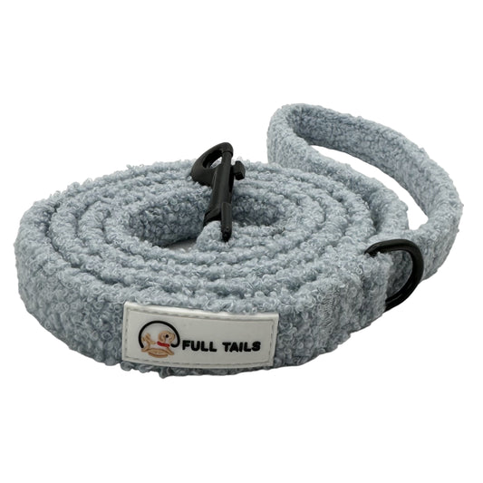 A gray teddy-textured dog leash with a padded handle and a metal clasp, featuring reflective stitching for safety.