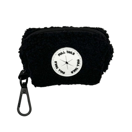 A black dog poop bag holder with a label that reads ' Teddy's Poop Bag Dispenser'. It has a ring for attaching to a leash or belt.