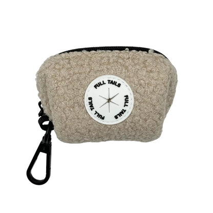 A beige dog poop bag holder with a black strap and a label in the center displaying a compass.
